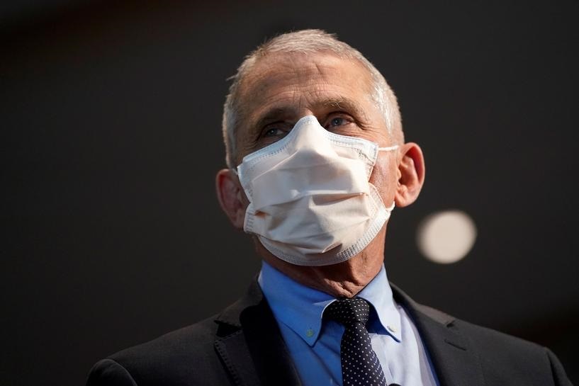 FILE PHOTO: Dr. Anthony Fauci, director of the National Institute of Allergy and Infectious Diseases, speaks with Health and Human Services Secretary Alex Azar before receiving his first dose of the new Moderna COVID-19 vaccine at the National Institutes 