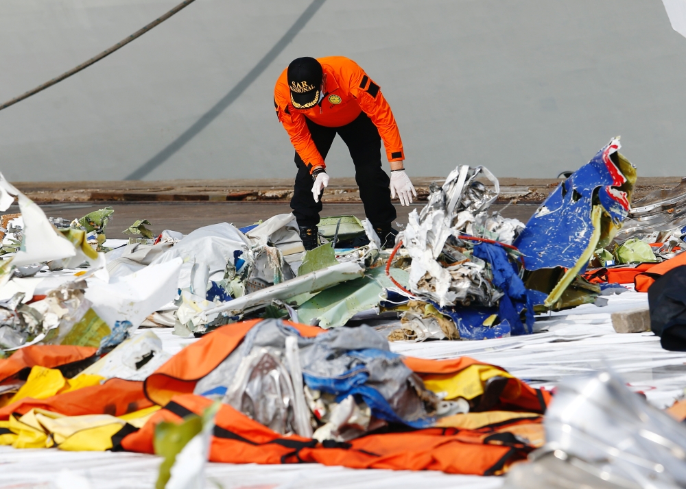 A member of Indonesia's rescue personnel observes the debris of Sriwijaya Air flight SJ 182, which crashed into the Java Sea, at the last day of the search and rescue operation, at Tanjung Priok port in Jakarta, Indonesia January 21, 2021. REUTERS/Ajeng D