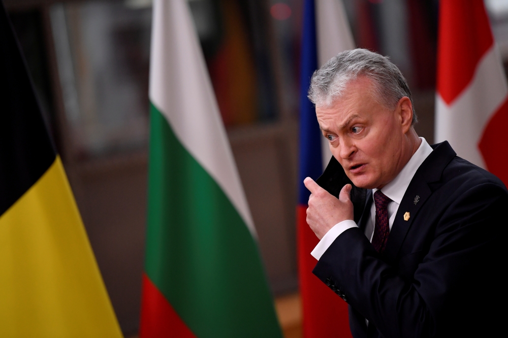 Lithuanian President Gitanas Nauseda takes off his mask as he arrives for a European Union summit during the coronavirus lockdown in Brussels, Belgium, December 10, 2020. John Thys/Pool via REUTERS/File Photo