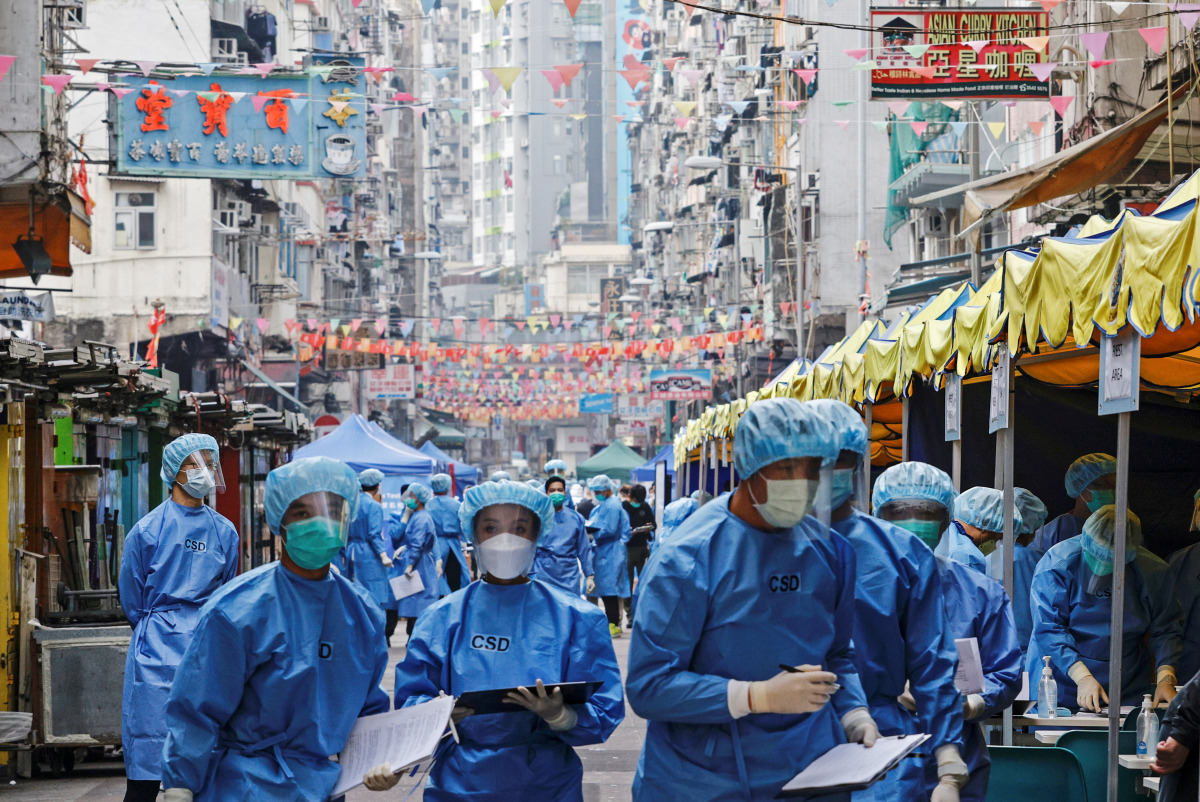 Health workers are seen in protective gear inside a locked down portion of the Jordan residential area to contain a new outbreak of the coronavirus disease (COVID-19), in Hong Kong, China January 23, 2021. REUTERS/Tyrone Siu TPX IMAGES OF THE DAY
