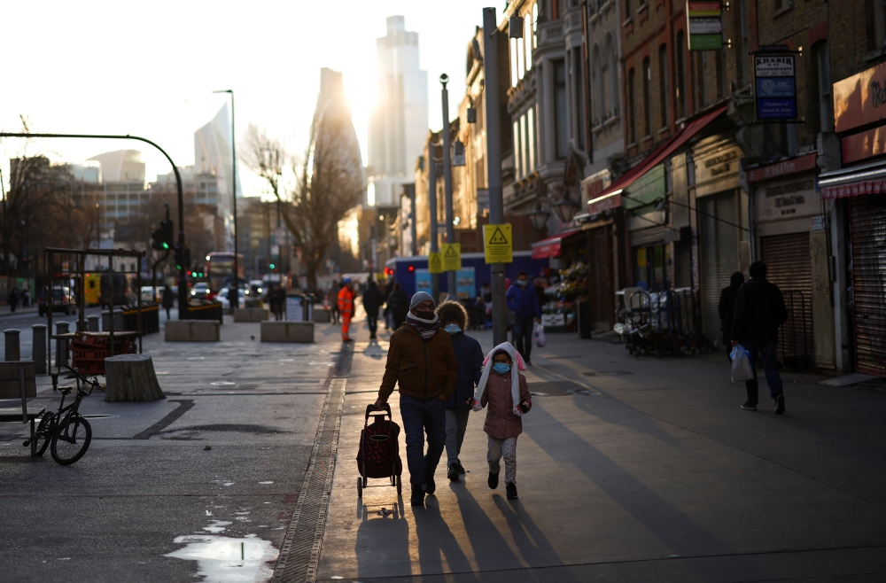 People walk past shops and market stalls, amid the coronavirus disease (COVID-19) outbreak, in east London, Britain, January 23, 2021. REUTERS/Henry Nicholls