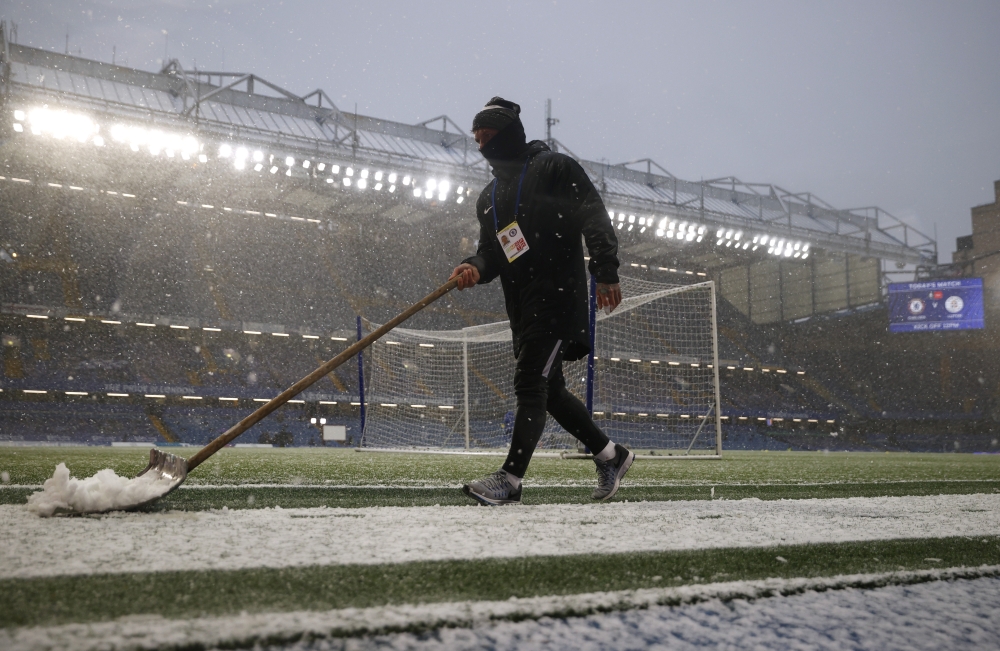 January 24, 2021 A member of groundstaff clears snow from the side of the pitch before the match Action Images via Reuters/John Sibley