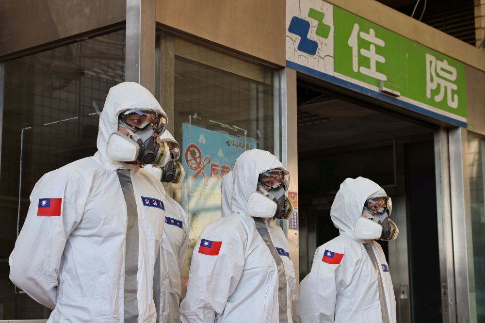 Soldiers prepare to spray disinfectant outside the Taoyuan General Hospital, where a cluster of coronavirus disease (COVID-19) infections was detected, in Taoyuan, Taiwan, January 19, 2021. REUTERS/Ann Wang