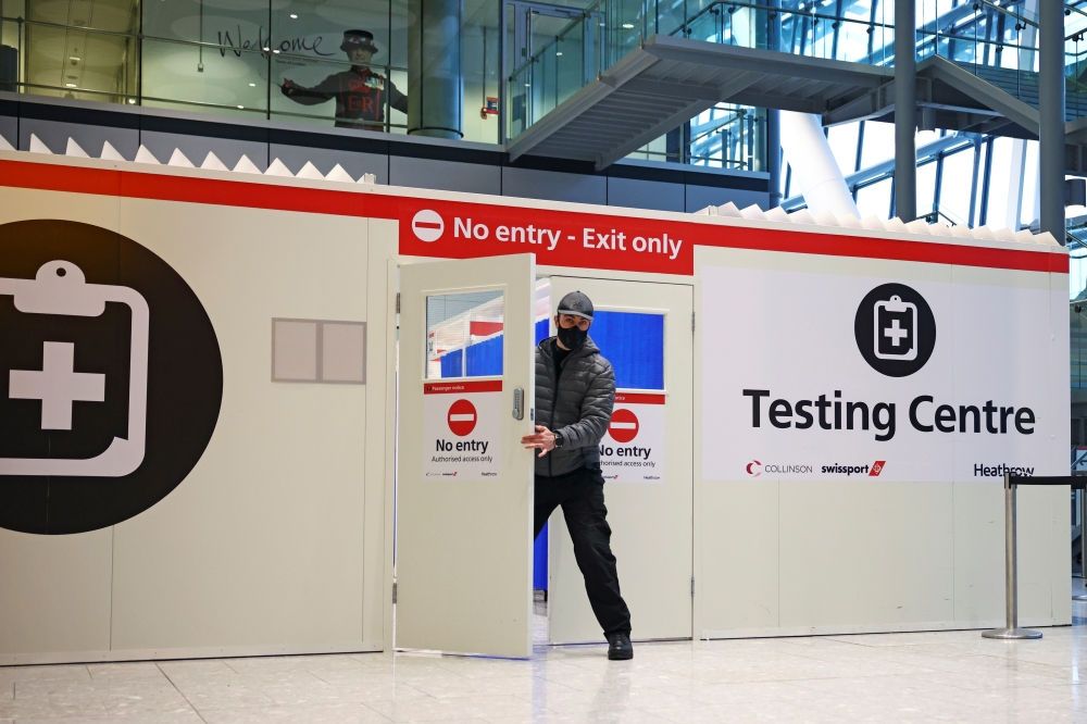 FILE PHOTO: A man opens the door of a testing center, as tighter rules for international travellers start, at Heathrow Airport, amid the spread of the coronavirus disease (COVID-19) pandemic, London, Britain, January 18, 2021. REUTERS/Henry Nicholls/File 