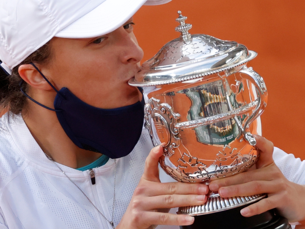 October 10, 2020. Poland's Iga Swiatek kisses the trophy as she celebrates after winning the French Open. REUTERS/Christian Hartmann/File Photo