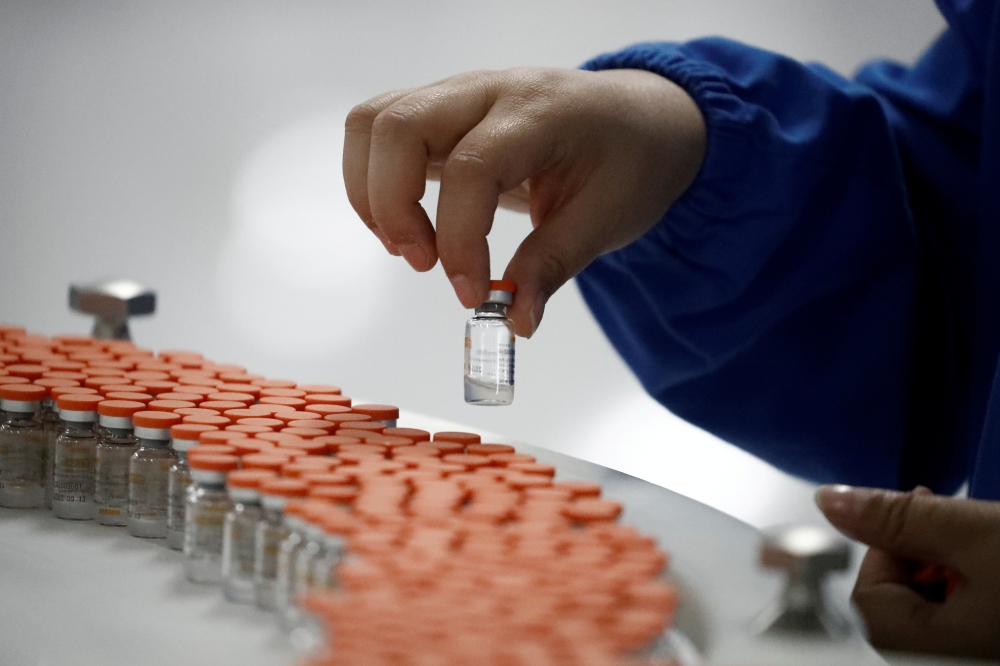 A worker performs a quality check in the packaging facility of Chinese vaccine maker Sinovac Biotech, developing an experimental coronavirus disease (COVID-19) vaccine, during a government-organized media tour in Beijing, China, September 24, 2020. REUTER