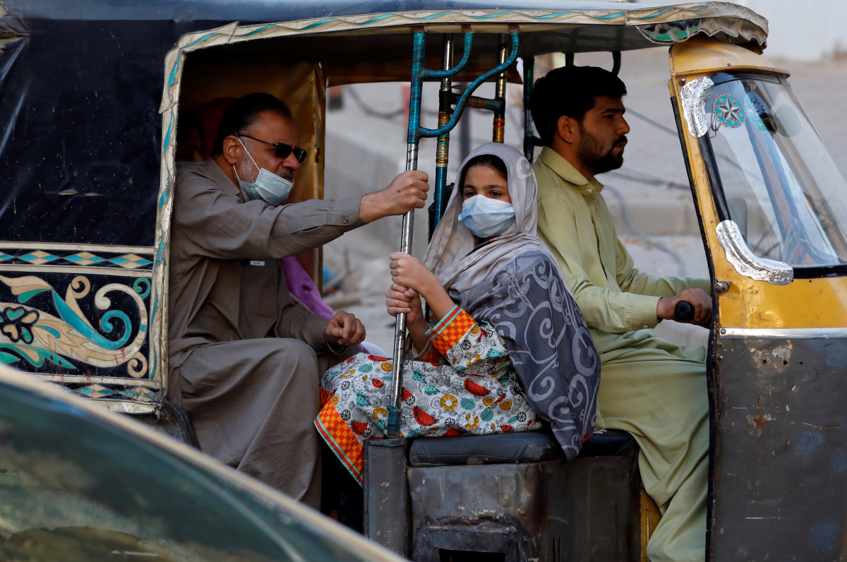 People with masks against COVID-19 travel by rikshaw (tok tok) in Karachi, Pakistan January 25, 2021. REUTERS/Akhtar Soomro
