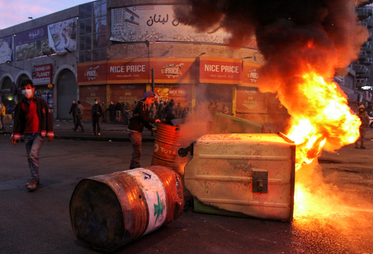 Garbage bins, set on fire by demonstrators, block a road during a protest against the lockdown and worsening economic conditions, amid the spread of the coronavirus disease (COVID-19), in Tripoli, Lebanon January 26, 2021. REUTERS/Omar Ibrahim
