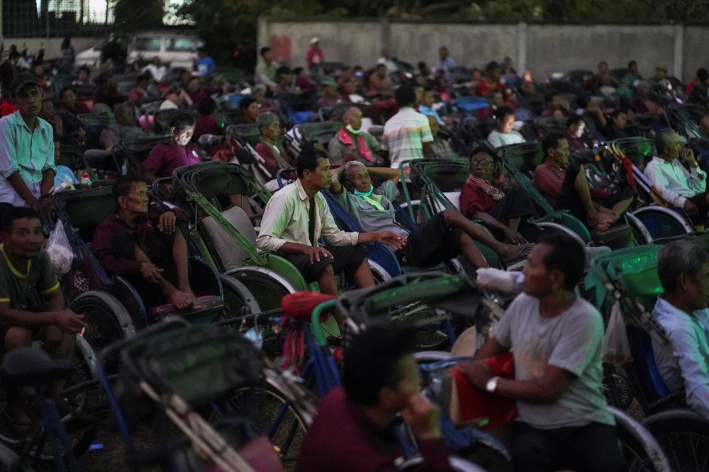 Tricycle drivers attend an outdoor movie screening held by a non-governmental organization (NGO). Reuters/Cindy Liu