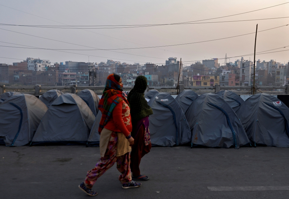 Women walk past rows of tents used by farmers who have gathered to protest against farm laws at Ghaziabad, India, January 28, 2021. Reuters/Danish Siddiqui