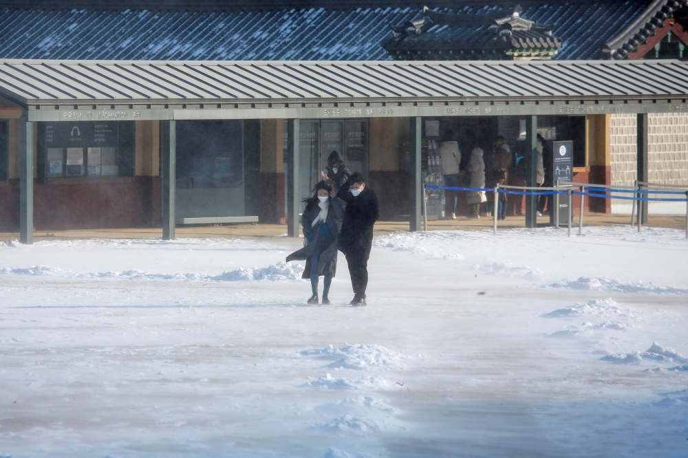 People take a walk on a cold winter day, amid the coronavirus disease (Covid-19) pandemic, at Gyeongbok Palace in central in Seoul, South Korea, January 28, 2021. REUTERS/Heo Ran