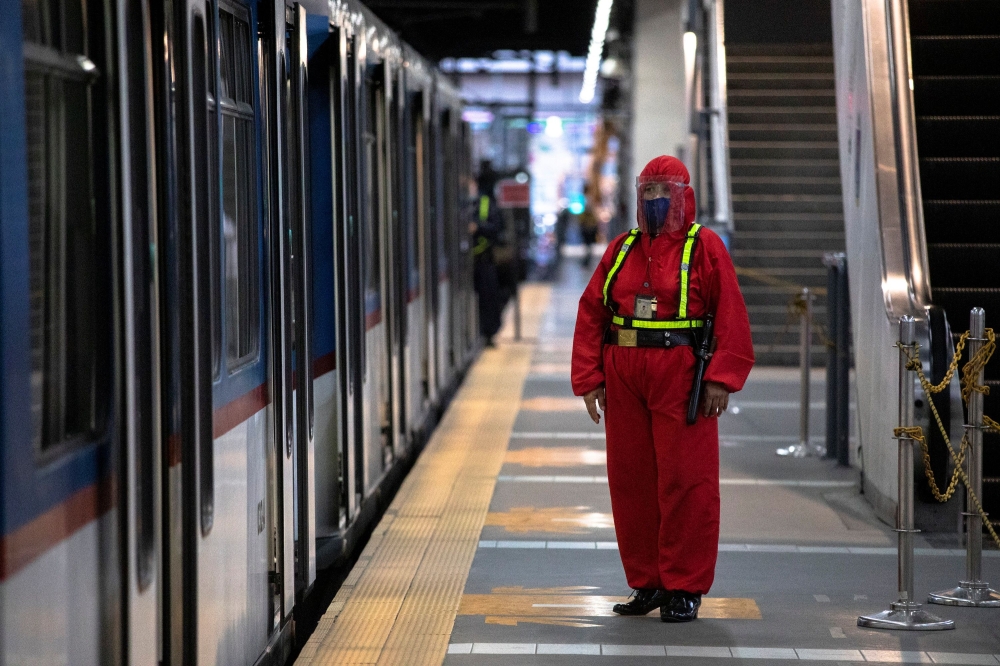 A security guard wearing a hazmat suit for protection against the coronavirus disease (COVID-19) stands beside a train in Manila, Philippines, January 29, 2021. REUTERS/Eloisa Lopez