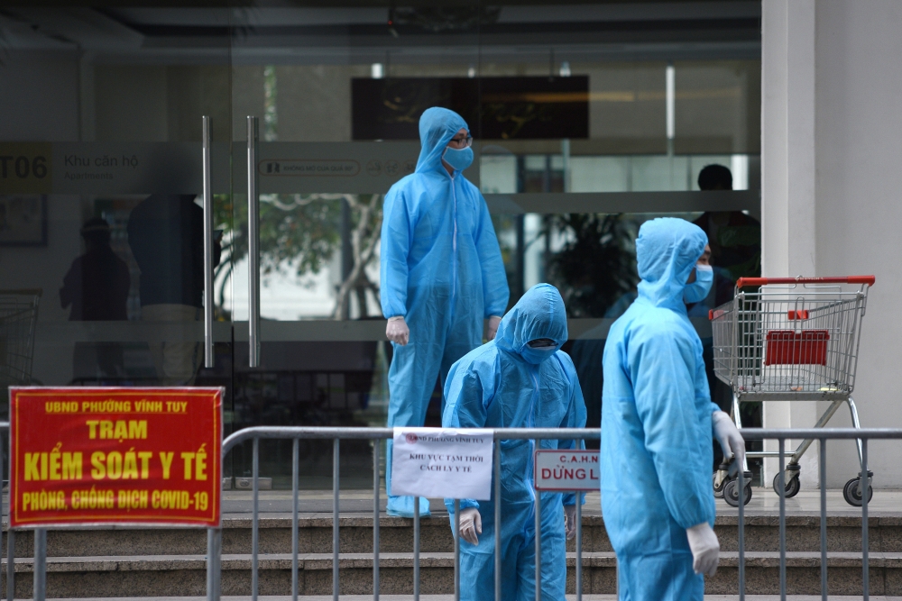 FILE PHOTO: Medical workers in protective suits stand outside a quarantined building amid the coronavirus disease (COVID-19) outbreak in Hanoi, Vietnam, January 29, 2021. REUTERS/Thanh Hue