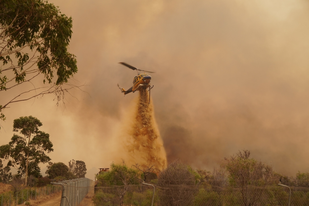 A helicopter flies overhead as its crew battles the Wooroloo Bushfire, northwest of Perth, Australia, February 2, 2021. Picture taken February 2, 2021. AAP Image/Supplied by Department of Fire And Emergency Services, Evan Collis/via REUTERS