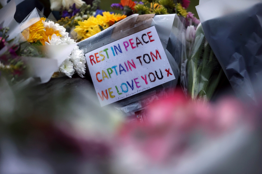 Flowers and notes are seen near the residence of Captain Sir Tom Moore, after his family announced that the centenarian fundraiser died, in Marston Moretaine near Milton Keynes, Britain February 3, 2021. REUTERS/Hannah McKay