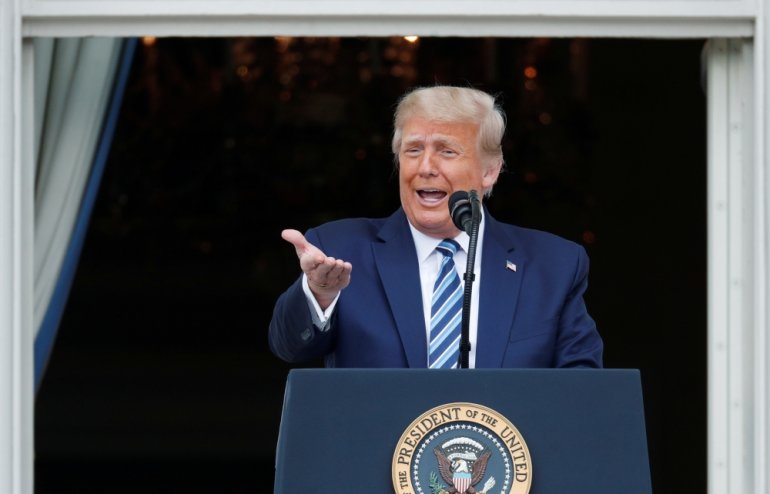 FILE PHOTO: US President Donald Trump stands on a White House balcony speaking to supporters gathered on the South Lawn for a campaign rally that the White House is calling a 