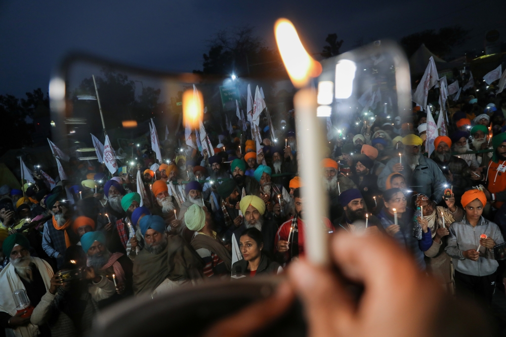 Farmers take part in a candlelit vigil, in memory of a person who died during a tractor rally on India’s Republic Day, as protests against farm laws continue, at Singhu Border near New Delhi, India, February 4, 2021. REUTERS/Anushree Fadnavis
