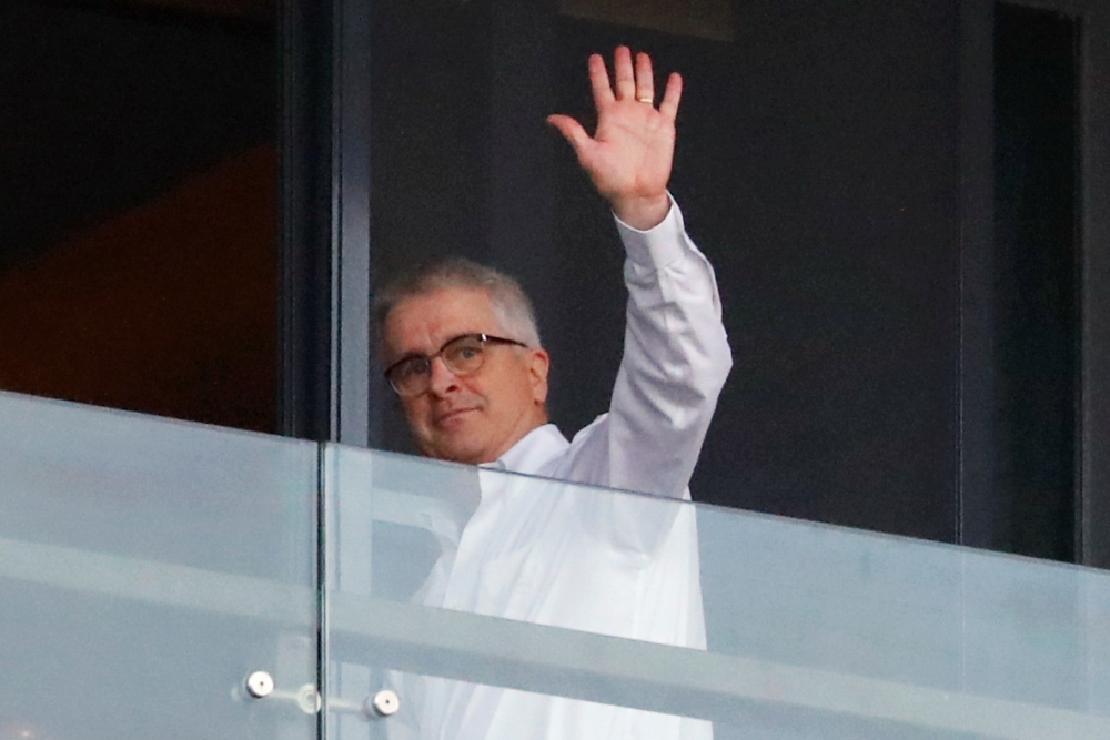 Dominic Dwyer, a member of the World Health Organization (WHO) team tasked with investigating the origins of the coronavirus disease (COVID-19), waves from a balcony at a hotel in Wuhan, Hubei province, China January 29, 2021. Picture taken January 29, 20