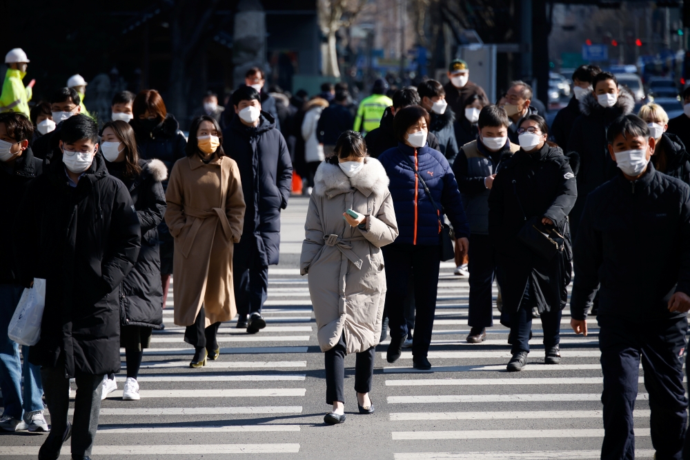 Commuters cross a zebra crossing, amid the coronavirus disease (COVID-19) pandemic in Seoul, South Korea, February 3, 2021. REUTERS/Kim Hong-Ji