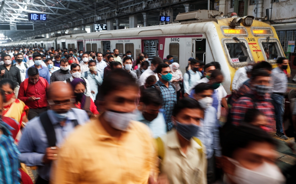 Commuters walk on a railway platform after disembarking from a train amidst the spread of the coronavirus disease (COVID-19) in Mumbai, India, February 9, 2021. REUTERS/Francis Mascarenhas