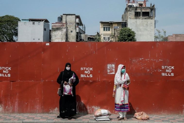 FILE PHOTO: Two Muslim women wearing protective masks stand on a side of the main road, in Colombo, Sri Lanka April 1, 2020. Dinuka Liyanawatte/Reuters
