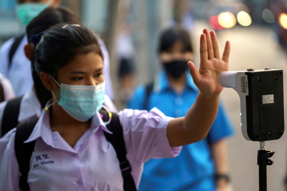 A student wearing a face mask undergoes a temperature check to prevent the spread of the coronavirus disease (COVID-19), as schools nationwide reopened in Bangkok, Thailand, February 1. 2021. REUTERS/Athit Perawongmetha/File Photo