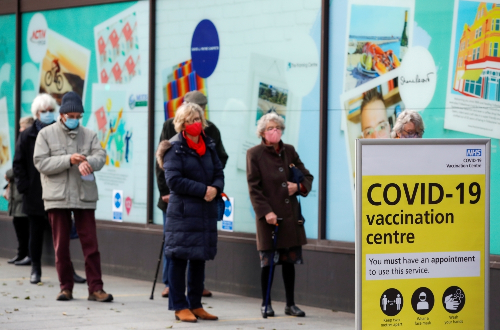 People queue to receive the coronavirus disease (COVID-19) vaccine outside a closed down Debenhams store that is being used as a vaccination centre in Folkestone, Kent, Britain January 28, 2021. REUTERS/Andrew Couldridge/File Photo