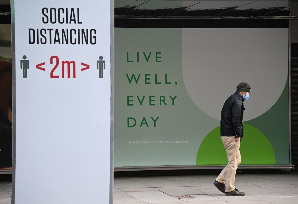A person walks past a closed shopfront on Oxford Street, as official figures are published for UK GDP in 2020, London, Britain, February 12, 2021. REUTERS/Toby Melville