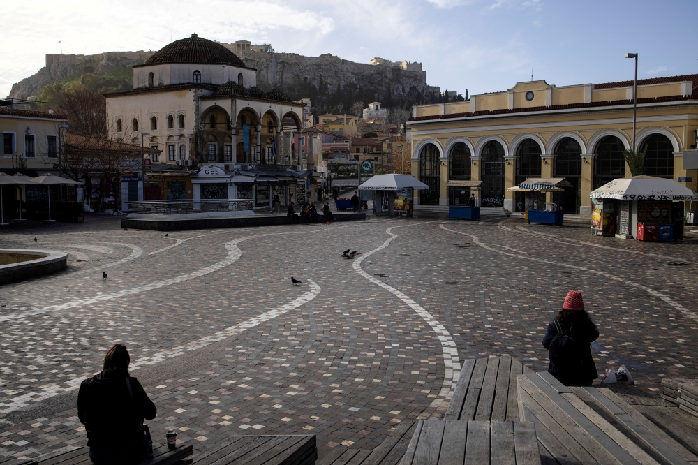 People sit in Monastiraki square after the Greek government imposed stricter lockdown measures against the coronavirus pandemic, in Athens, Greece, February 11, 2021. REUTERS/Alkis Konstantinidis/File Photo