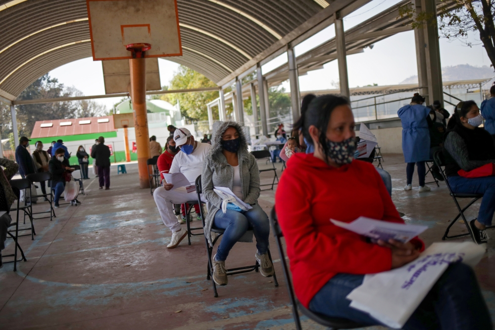 People wait before a healthcare worker takes a sample for the COVID-19 rapid antigen testing, at the Iztapalapa neighbourhood in Mexico City, Mexico, February 5, 2021. REUTERS/Henry Romero