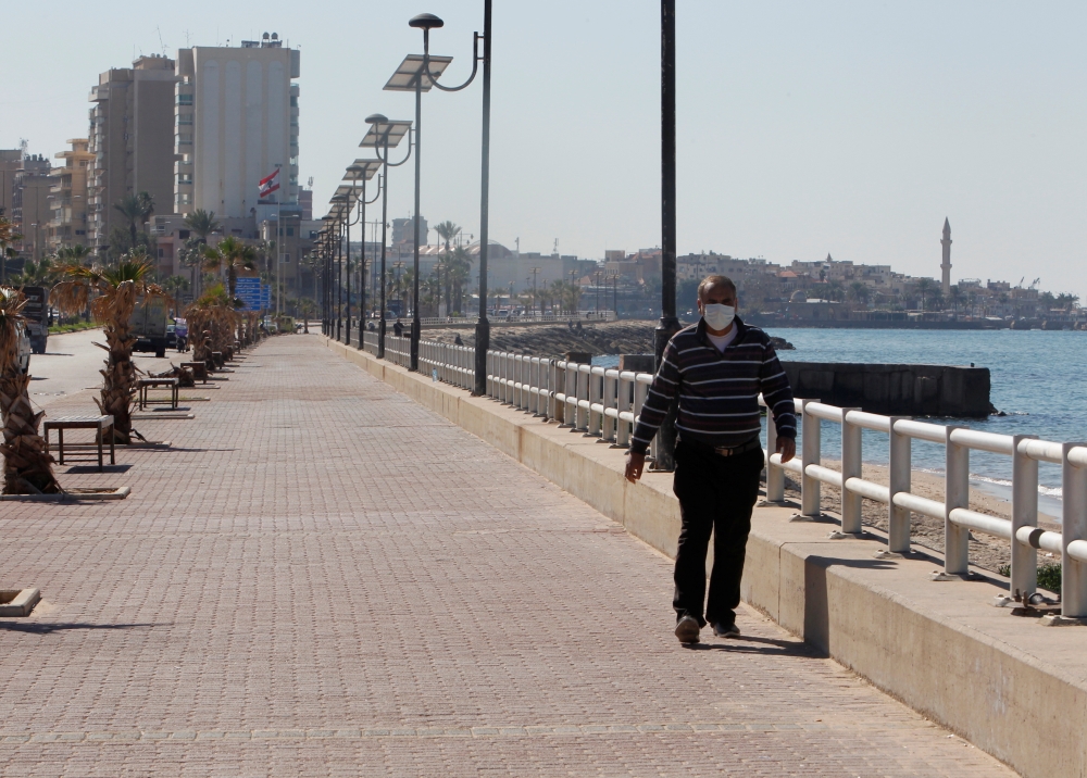 A man wearing a face mask walks along a corniche, amid the spread of the coronavirus disease (COVID-19), in Sidon, Lebanon February 9, 2021. REUTERS/Aziz Taher