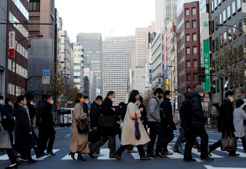 Pedestrians wearing protective masks, following the coronavirus disease (COVID-19) outbreak, make their way during commuting hour at a business district in Tokyo, Japan, January 7, 2021. REUTERS/Kim Kyung-Hoon/File Photo