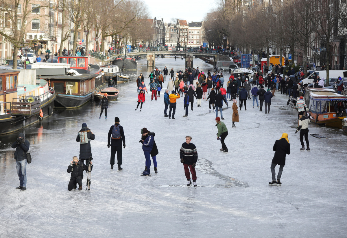 People ice skate during a cold snap across the country at the Prinsengracht in Amsterdam, Netherlands February 14, 2021. REUTERS/Eva Plevier
