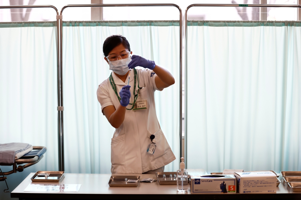 A medical worker fills a syringe with a dose of the Pfizer-BioNTech coronavirus disease (COVID-19) vaccine as Japan launches its inoculation campaign, at Tokyo Medical Center in Tokyo, Japan February 17, 2021. Behrouz Mehri/Pool via REUTERS