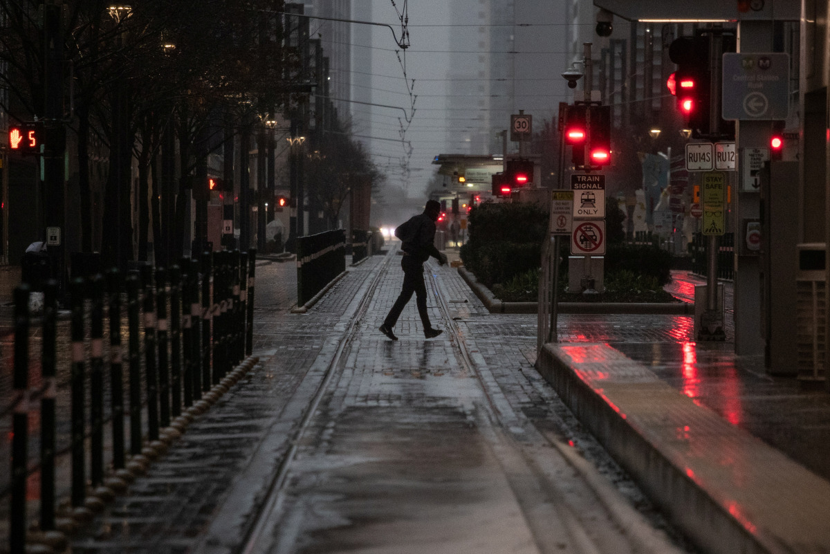 A man crosses Main Street in downtown during record-breaking temperatures in Houston, U.S., February 17, 2021. REUTERS/Adrees Latif

