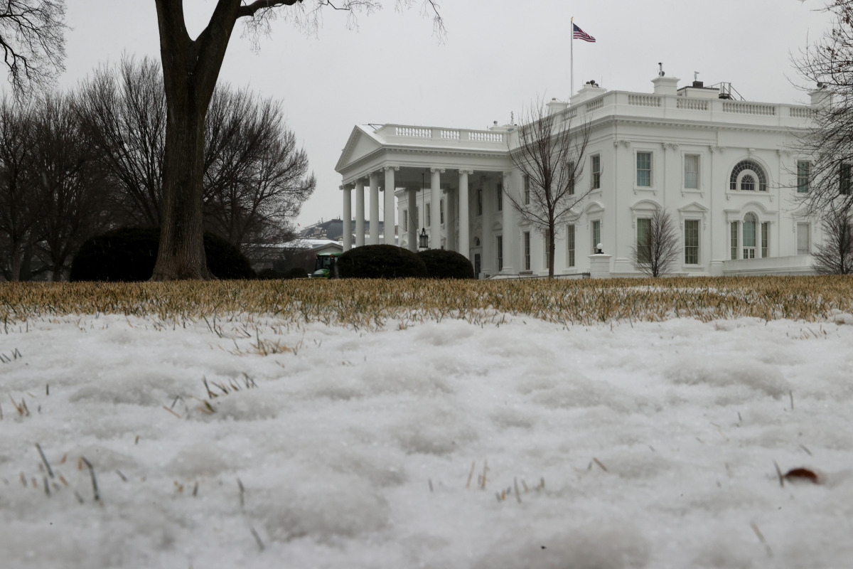 A thin coating of snow and ice covers the lawn in front of the White House in Washington, U.S. February 18, 2021. REUTERS/Jonathan Ernst
