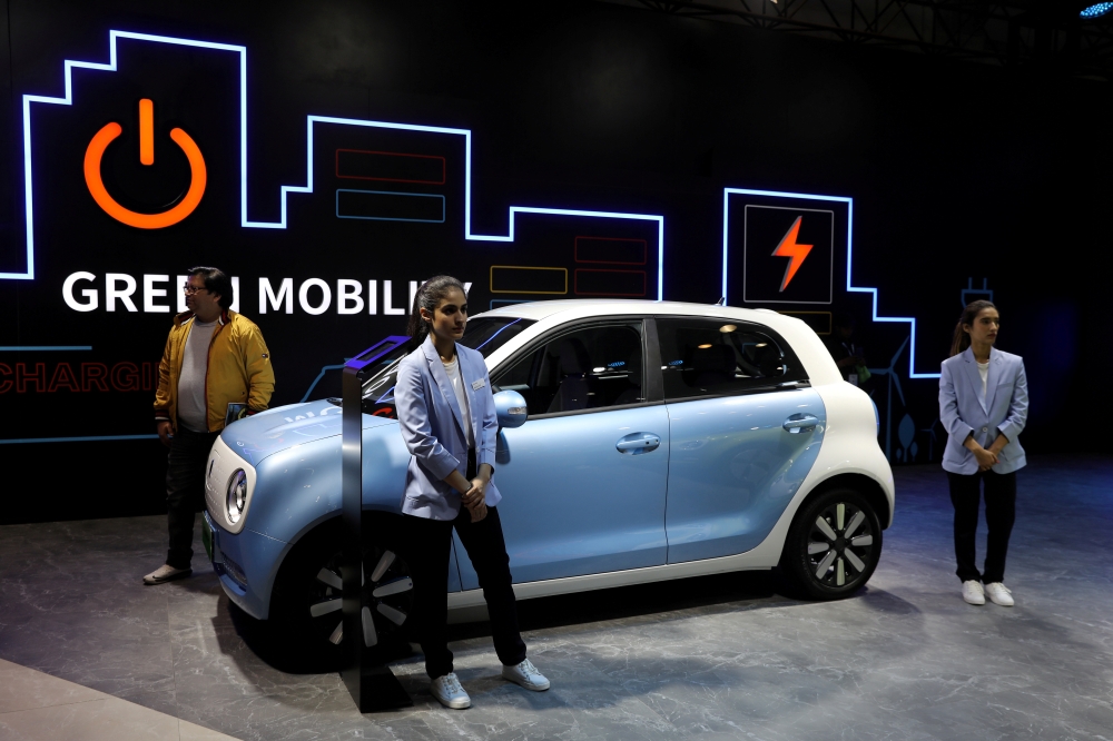 Models pose next to Great Wall Motors (GWM) GWM R1 electric car at its pavilion at the India Auto Expo 2020 in Greater Noida, India, February 5, 2020. REUTERS/Anushree Fadnavis/File Photo
