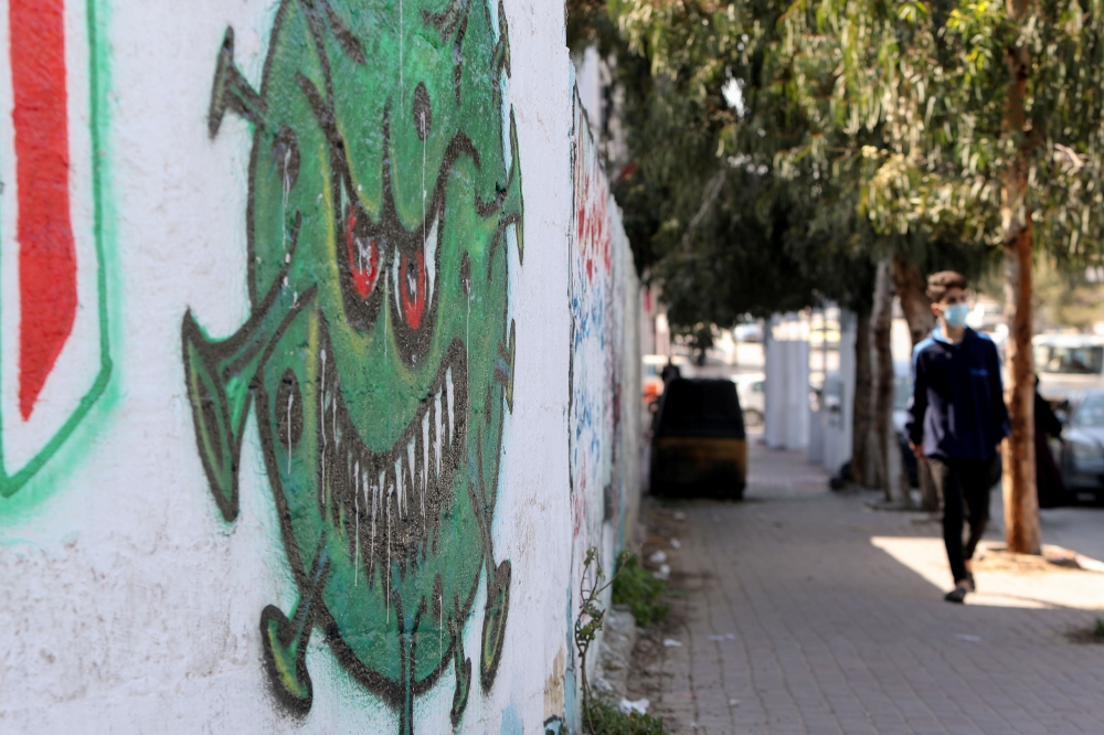 A coronavirus-themed mural is seen on a wall amid the coronavirus disease (COVID-19) outbreak, in Gaza City, February 16, 2021. REUTERS/Mohammed Salem