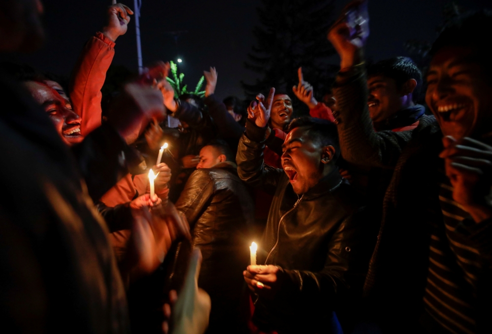 Supporters of a faction of the ruling Nepal Communist Party sing and dance as they hold candles after Nepal's top court ordered the reinstatement of the nation's parliament, in Kathmandu, Nepal February 23, 2021. REUTERS/Navesh Chitrakar