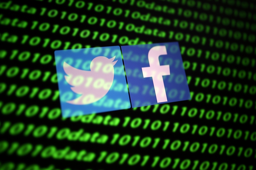 FILE PHOTO: The Twitter and Facebook logo along with binary cyber codes are seen in this illustration taken November 26, 2019. REUTERS/Dado Ruvic/Illustration