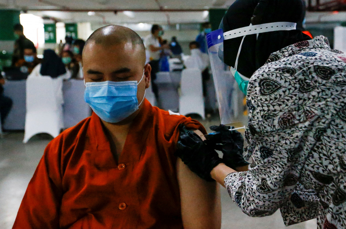 A monk reacts while receiving the first dose of China's Sinovac Biotech vaccine for the coronavirus disease (COVID-19) during the mass vaccination program for clergy at the parking lot of Grand Istiqlal Mosque in Jakarta, Indonesia, February 25, 2021. REU