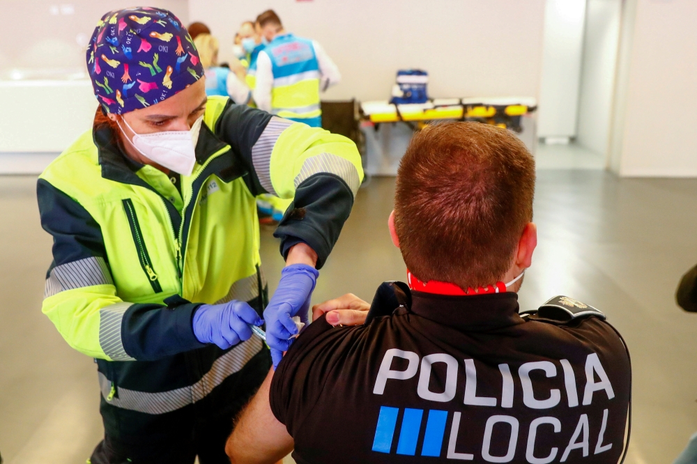 A police officer receives his first dose of the AstraZeneca COVID-19 vaccine, as the coronavirus disease (COVID-19) outbreak continues, at Atletico Madrid's Wanda Metropolitano stadium in Madrid, Spain, February 25, 2021. REUTERS/Sergio Perez/File Photo