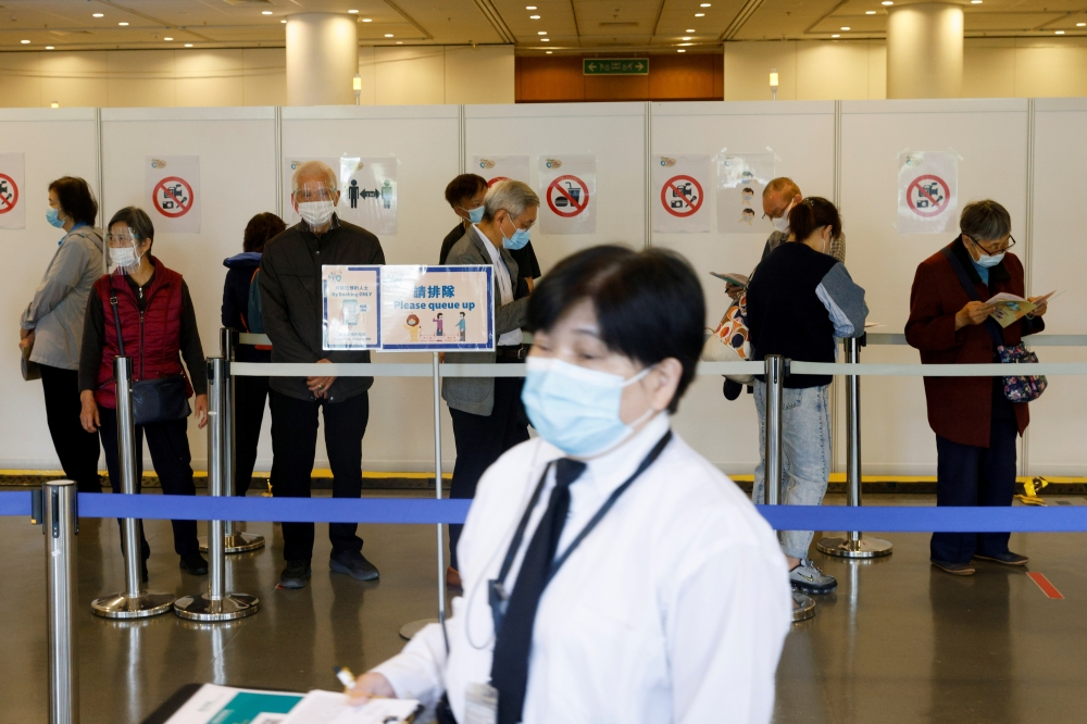 People queue up at a community vaccination centre to receive a dose of the Sinovac Biotech coronavirus disease (COVID-19) vaccine, in Hong Kong, China, February 26, 2021. REUTERS/Tyrone Siu