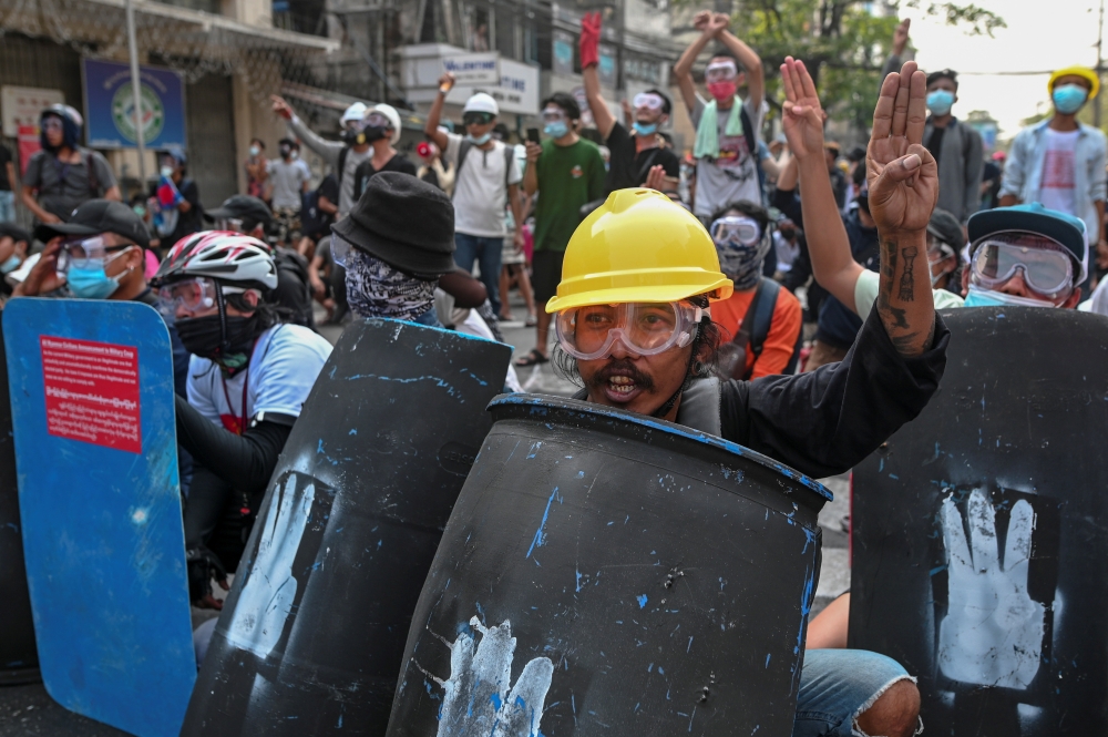Protesters flash three-finger salutes and hold shields during a rally against the military coup in Yangon, Myanmar, February 27, 2021. REUTERS/Stringer
 