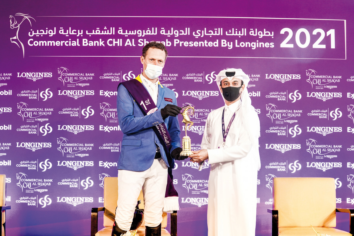 Germany’s Christian Ahlmann, the  CHI Al Shaqab Grand Prix winner who captured major honours on the final day of the Commercial Bank CHI Al Shaqab Presented by Longines, receiving his trophy from Event Director and Organising Committee Member Omar Al Mann