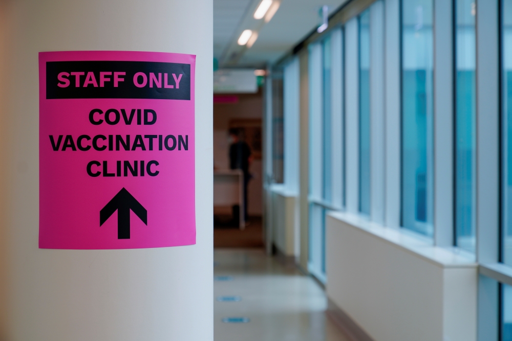 A sign for a COVID-19 vaccination clinic is seen as high-risk workers receive the first vaccines in the state of Victoria's rollout of the program, in Melbourne, Australia, February 22, 2021. REUTERS/Sandra Sanders