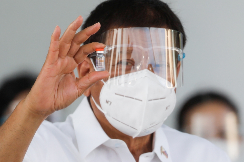 Philippine President Rodrigo Duterte holds a vial of Sinovac’s coronavirus disease (COVID-19) vaccine, the first COVID-19 vaccine to arrive in the country, at Villamor Air Base, Pasay City, Metro Manila, Philippines, February 28, 2021. REUTERS/Eloisa Lope