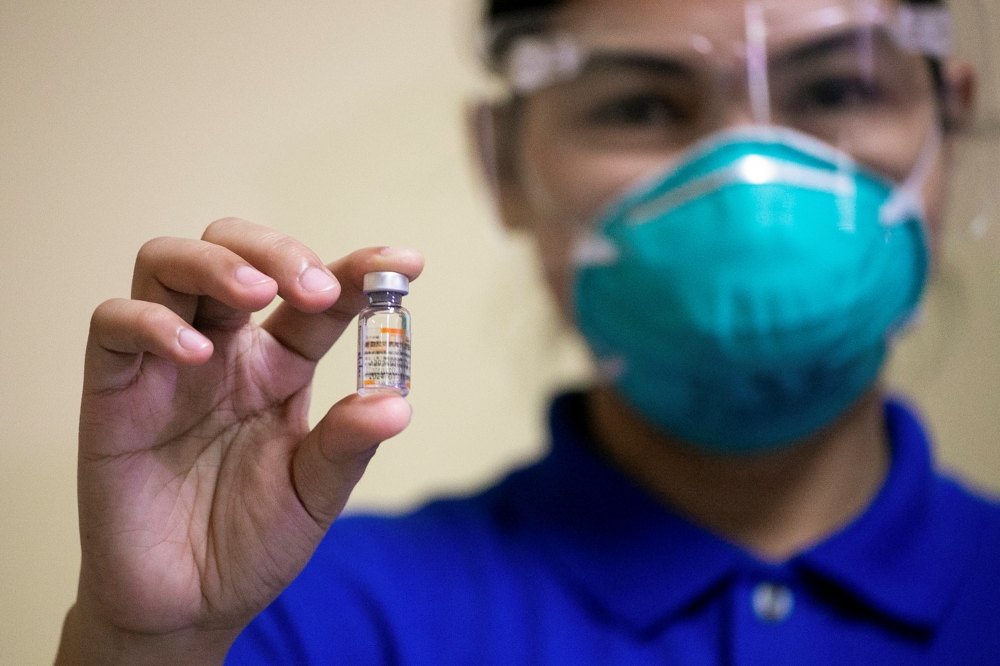 A health worker holds a vial of Sinovac Biotech's Coronavac vaccine on the first day of the coronavirus disease (COVID-19) inoculation drive in the Philippines, at the Lung Center of the Philippines, Quezon City, Metro Manila, March 1, 2021. REUTERS/Elois