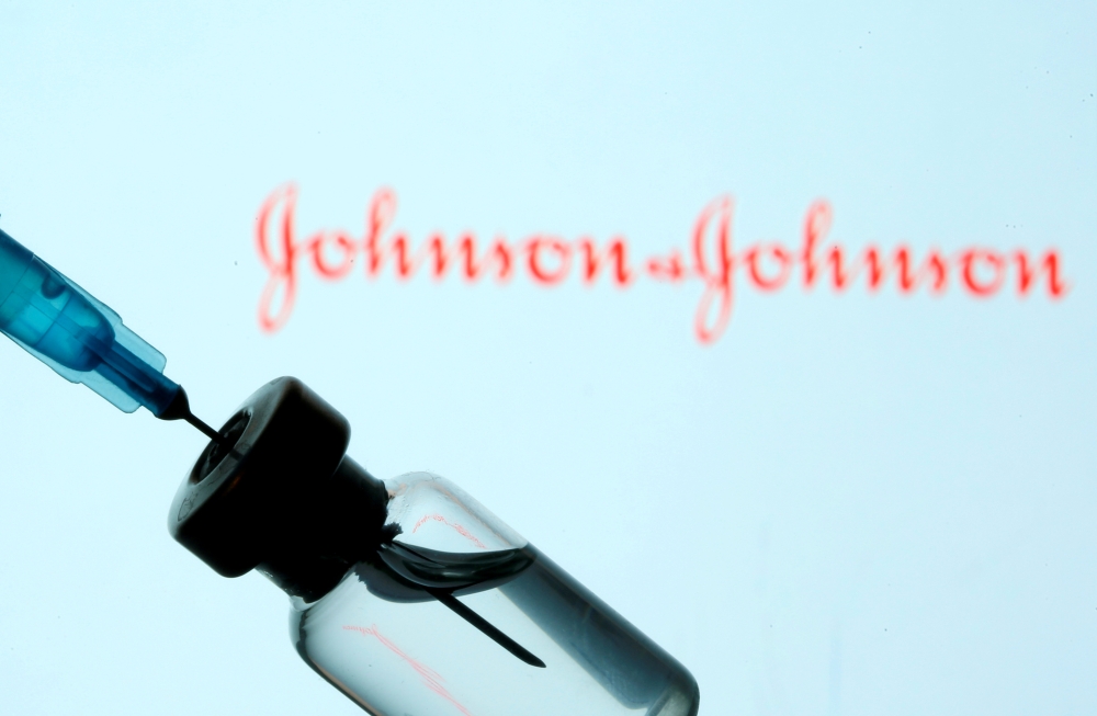  A vial and sryinge are seen in front of a displayed Johnson&Johnson logo in this illustration taken January 11, 2021. REUTERS/Dado Ruvic/Illustration/File Photo/File Photo