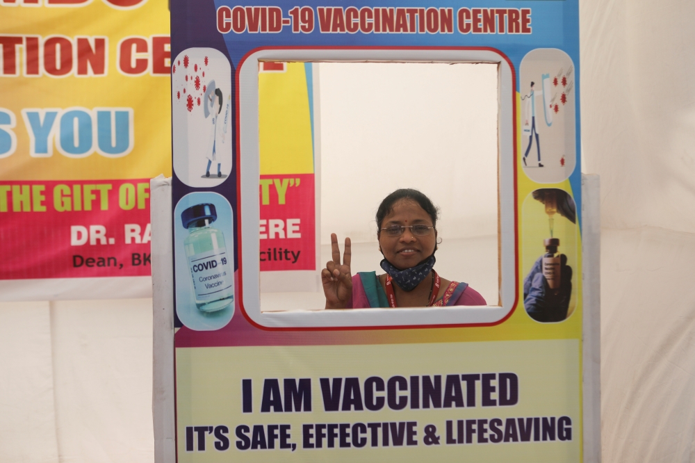  A woman poses for a picture with a cardboard cutout after receiving a dose of COVISHIELD, a COVID-19 vaccine manufactured by Serum Institute of India, at a vaccination centre, after second wave of vaccination started for the elderly with comorbidities, a